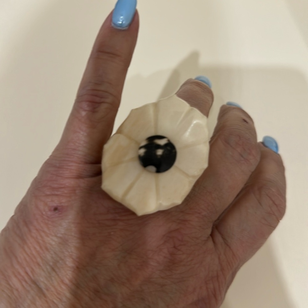 Carved ivory ring with verigated black stone on the top.